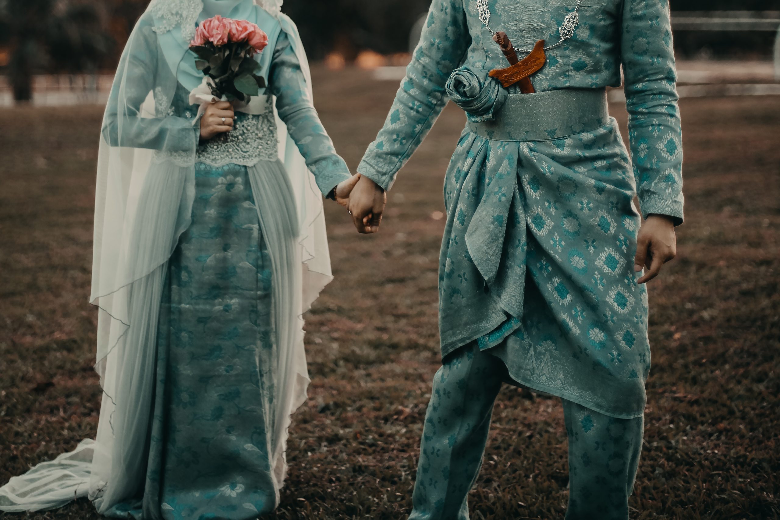 midsection-bride-groom-holding-hands-flower-bouquet