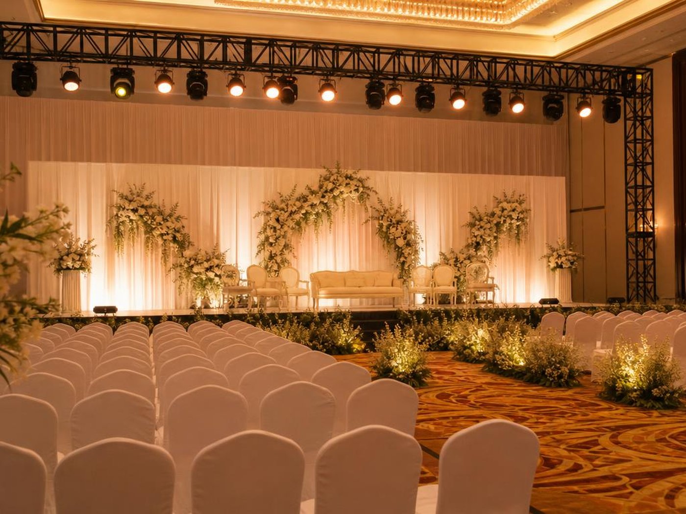 Tata cahaya panggung acara di ballroom hotel dengan backdrop tirai putih