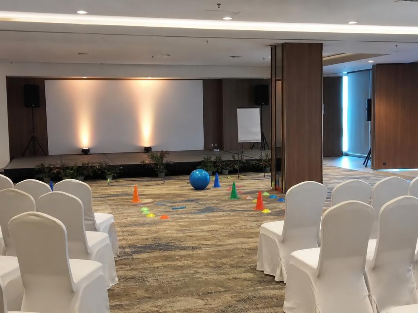 Hall gathering kantor dengan panggung dan area permainan yang tertata