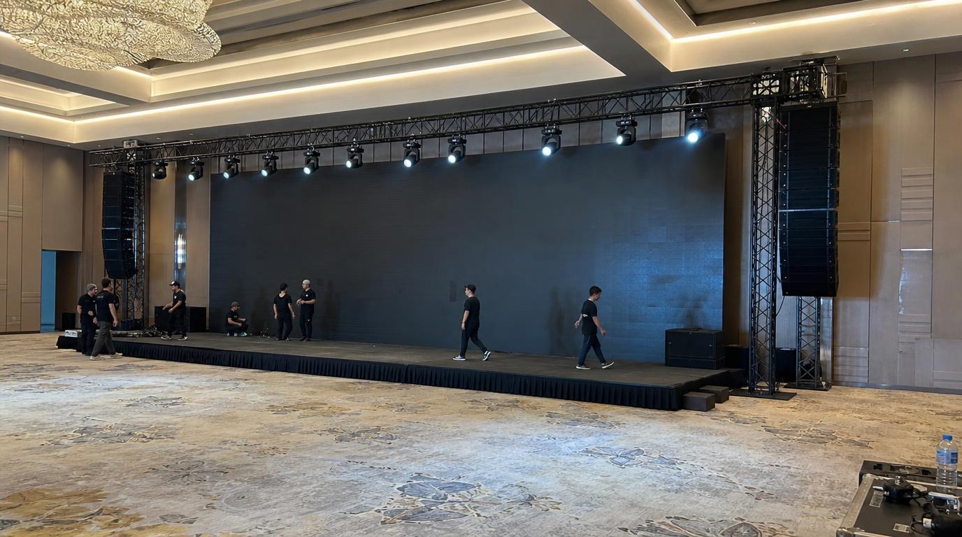 Setup panggung: riser, LED screen, truss lighting, line array speaker, dan kru produksi